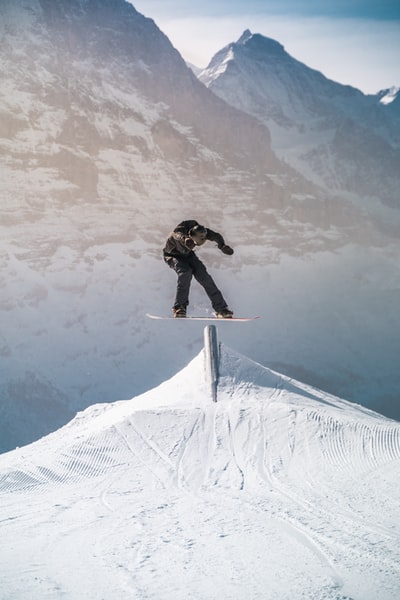 Black pants wearing a black jacket on skis during the day
